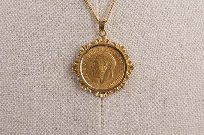 un collier en or orné d'une pièce de monnaie, porté par un mannequin