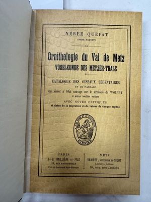 un vieux livre à la couverture dorée posé sur une table blanche