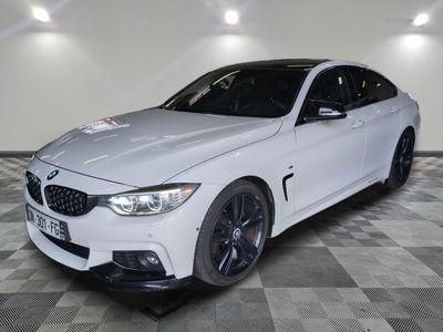 the white bmw m4 coupe is parked in a showroom