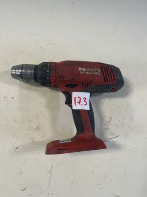 une perceuse rouge posée sur une table
