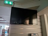 a flat screen tv mounted on the wall above a fire hydrant