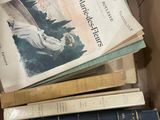 une boîte remplie de livres empilés les uns sur les autres