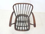 a wooden chair with a black seat on a white floor