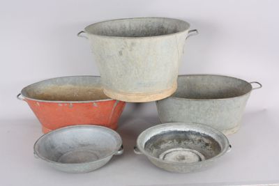 several metal pots and pans are sitting on a white surface