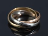 two gold and silver rings on a black surface