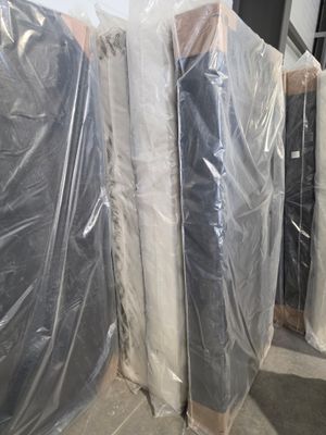 de nombreux matelas emballés dans du plastique dans une pièce