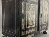 an antique black and gold painted cabinet with two doors and drawers