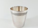 a silver cup that is sitting on a white surface