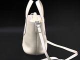 a small white bag with a handle on a black background