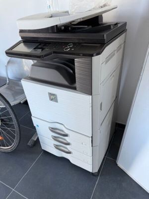 une imprimante blanche et un vélo noir et blanc dans une pièce