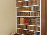 une bibliothèque remplie de livres, placée dans un coin de la pièce