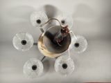overhead view of a chandelier with six glass vases and a candle holder