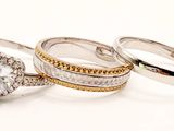 three wedding rings with diamonds on them on a white surface