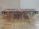 a marble table with a metal base on a wooden floor