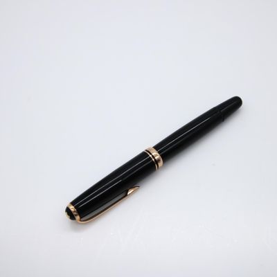 a black and gold pen sitting on top of a white surface