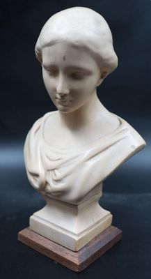 marble bust of a woman on a wooden base on a black background