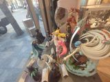 anime figurines displayed in a store window on a city street