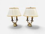 une paire de lampes de table en laiton avec des abat-jours blancs