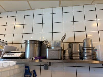 de nombreuses casseroles et poêles sur l'étagère de la cuisine