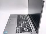 a silver laptop with a black keyboard on a white surface