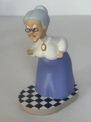 une figurine représentant une vieille femme assise sur un damier