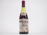 une vieille bouteille de vin posée sur une table blanche