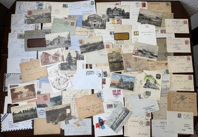 de nombreuses cartes postales anciennes posées sur une table, dont il y a beaucoup