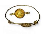 un gros plan d'un bracelet orné d'une pièce d'or