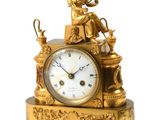 une horloge en or surmontée d'une statue