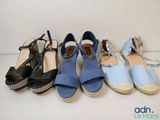 several pairs of shoes are lined up in a row on a white surface