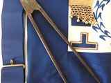 a blue apron with a pair of scissors and a hat on it