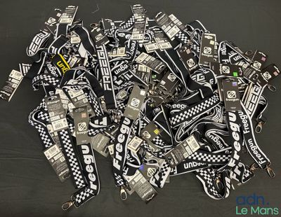 a pile of black and white lanyards on a table