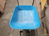 a blue wheelbarrow that is sitting in a garage
