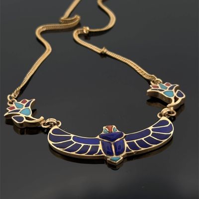 un collier en or orné d'ailes en émail bleu et vert