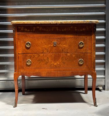 an antique chest of drawers with marble top in the middle of a room