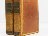 an old book sitting on top of a white table next to a white wall