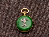une photo d'une montre de poche verte et dorée