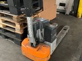 un chariot élévateur transportant une palette dans un entrepôt