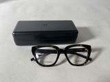 glasses are laying on a white surface next to a black box