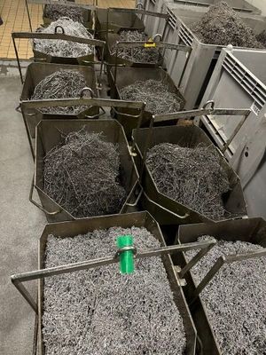 de nombreuses poubelles remplies de papier déchiqueté et une bouteille verte