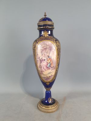 un vase bleu et or sur lequel est représentée une femme