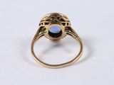 an image of a gold ring with a blue stone in the center
