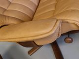 a tan leather chair with a wooden frame and a brown leather seat