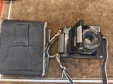 un appareil photo et un portefeuille posés sur une table