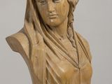 carved wooden bust of a woman with a veil on her head