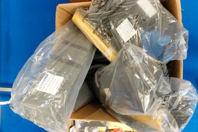 une boîte en carton remplie d'objets divers posée sur une surface bleue