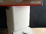 une cuvette de WC blanche posée sur une table en bois