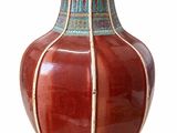 a red vase with a blue and white design on it