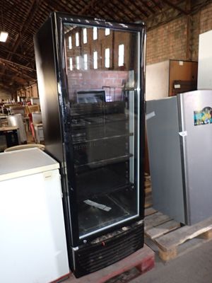 two refrigerators and a refrigerator freezer in a warehouse