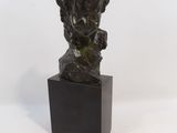statue d'une femme avec une fleur dans les cheveux, posée sur un socle noir